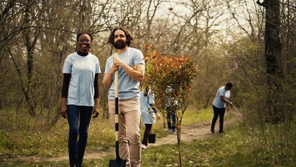 Portrait of diverse activists team tidying natural environment by working on reforestation and engaging in litter cleanup, recycle garbage. Volunteers protecting wildlife and ecosystems. Camera B.