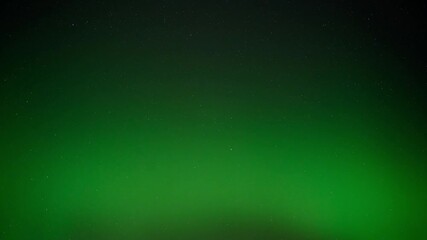 Wall Mural - pale to bright green aurora swirl across the star filled night sky in this time lapse.