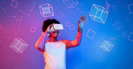 African girl with VR glasses standing at blue and pink background and looking at floating geometric shape. Excited person searching and entering visual reality world. Technology innovation. Ingenuity.