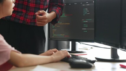 Slow motion back end or software developer manager supervising his team on new application program development on debugging and solving complex code algorithms on monitor. Burgeoning