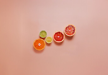 Aufkleber - Citrus fruit slices in various colors against a pink background.