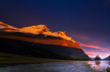 Poster - A peaceful sunrise over a tranquil lake, with mountain peaks reflecting in the still water.