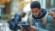 © Naknakhone - A student reviewing study materials on a mobile device while on the go.