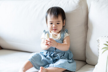 A 1 year old Taiwanese girl spending time playing happily with her parents, a man and woman in their 20s, in a room of a high rise apartment in Taichung City, Taiwan.