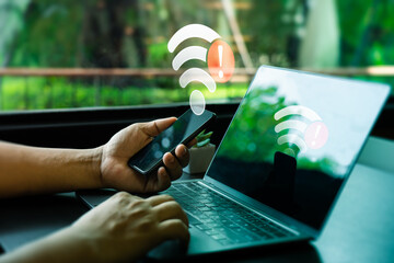 person holding smartphone and laptop with wi-fi connection error warning in modern workplace. intern