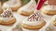© Luxetify - Close up of a hand decorating a sugar cookie with white icing and sprinkles.