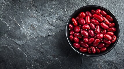Poster - Red kidney beans in a black bowl on grey stone background Top view : Generative AI