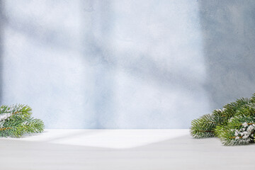 Aufkleber - Christmas template featuring snowy fir tree branches on a table with shadows and sun glares softly falling on the wall