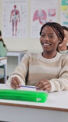 Poster - Education, laughing and student black woman at desk in classroom for lecture, lesson or study. Funny, happy and smile of learner at college, school or university for growth, learning and development