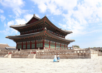 Geunjeongjeon Hall, Gyeongbokgung palace, Seoul, South Korea. Two girls dressed in traditional dress hanbok near to the main throne hall of Gyeongbokgung Palace