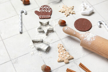 Wall Mural - Christmas gingerbread cookies, baking molds and rolling pin on white tile background