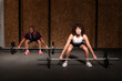 © Westend61 - Woman with fitness instructor practicing deadlift with barbell at gym