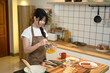 © Prathankarnpap - Happy young Asian woman whisking eggs in a glass bowl, preparing breakfast in a kitchen