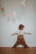 © Halfpoint - Portrait of an adorable little girl standing under paper garland.