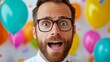© Nataliia_Trushchenko - Man with glasses and a beard is standing in front of a wall full of balloons. He is looking surprised and is wearing a white shirt and a bow tie. narcissist man having a birthday party