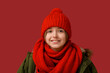 © Pixel-Shot - Cute little boy in warm winter clothes on red background