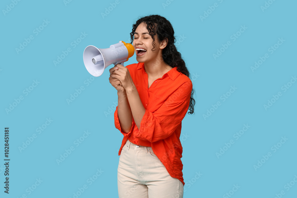Young African-American woman with megaphone on blue background