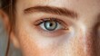 © Pattanan - Close-up portrait showcasing the beauty of a blue eye with freckles, capturing emotion and detail in natural lighting.
