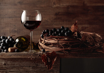 Glass and bottle of red wine on an old wooden table.