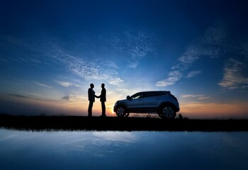 Aufkleber - Two people in silhouette shake hands in front of a car at sunset. The car's reflection is visible in the water.