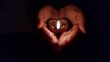 © Wirestock - Hands Holding a Lit Clay Lamp in the Dark
