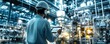 © tanapat - High-tech industrial setting with a factory worker monitoring systems through a tablet, illuminated by futuristic lighting and machinery