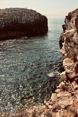 Wall Mural - Rocky cliffs and sparkling sea under clear sky