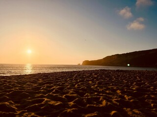 Serene beach sunset with warm glow over the ocean.