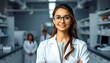 © Harry - The picture shows a beautiful young woman wearing a white coat and glasses in a modern Medical Science Laboratory with a team of specialists in the background