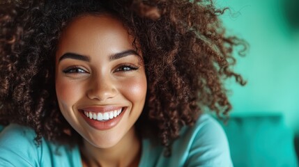 A woman with vivid curly hair beams a brilliant smile, her face filled with joy and delight, surrounded by a bright background, radiating happiness and warmth effortlessly.