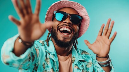 A cheerful man, wearing bright floral attire and reflecting sunglasses, energetically poses against a vivid teal background, exuding positivity and fun.