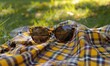 © Alexey - Pair of sunglasses on the picnic blanket, 4K hyperrealistic photo