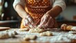 © JoxyAimages - Hands are seen forming dough on a flour-covered wooden table, surrounded by cooking tools, capturing the artisanal process of traditional baking.