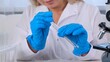© Евгения Медведева - professional scientist takes a sample for a medical experiment. A research chemist works in a laboratory with a micropipette and a microscope