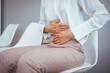 © Dragana Gordic - Woman Experiencing Stomach Pain While Sitting In Chair