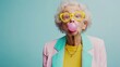 © Nataliia_Trushchenko - Woman in yellow jacket blowing a bubble. The bubble is pink and the woman is wearing yellow glasses. elderly woman blowing a pink bubble gum, wearing yellow glasses, jacket, vibrant color background,