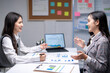 © Wasana - Two young businesswomen discussing financial report with charts and data at the office