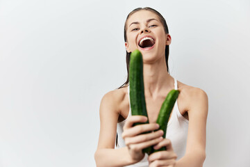 Happy young woman holding cucumbers, smiling joyfully Fresh vegetables, healthy lifestyle, natural beauty, organic food Bright white background enhances the cheerful mood