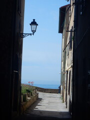 a street in Piombino with a man looking at the sea, Livorno Province, Tuscany, Italy