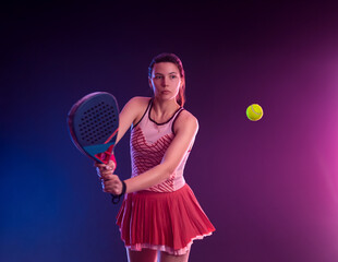 Padel tennis player with racket on open tournament. Girl athlete with paddle racket on court with neon colors. Sport concept. Social events open tour