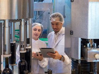 Engineer staff man and woman two person smile talk and inspect check quality control working job in beverages vats barrels modern technology factory production pattern industry plant in warehouse.