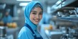 © Irina Ukrainets - A smiling woman in a blue hijab stands in a modern kitchen. She wears an apron and works with confidence. This image embodies warmth and professionalism in culinary arts. AI