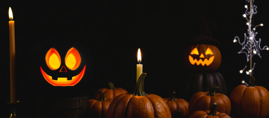 Poster - black pumpkin with a grinning face lit by a candle