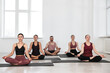 © New Africa - Group of people meditating on mats in yoga class