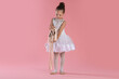 © New Africa - Little ballerina with pointe shoes on pink background