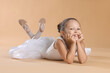 © New Africa - Portrait of little ballerina on beige background