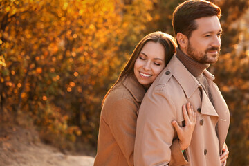 Poster - Beautiful couple hugging in autumn park, space for text