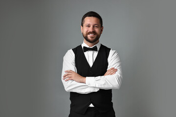 Poster - Portrait of professional croupier on grey background