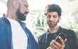 © BullRun - Stylish chatting men sharing mobile phone
