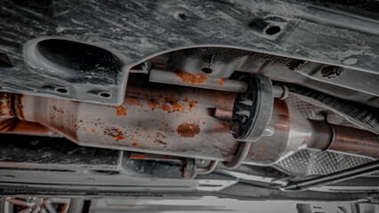 Close-up of old exhaust resonator on exhaust system of vehicle